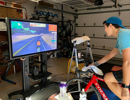 Justin Koga, a senior political science, history, and statistics student, rides virtually at his home in Irvine, California.