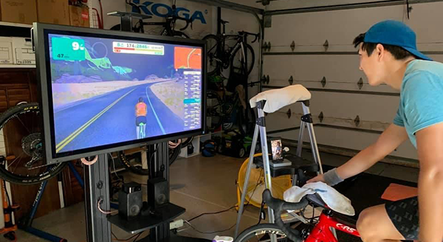 Justin Koga, a senior political science, history, and statistics student, rides virtually at his home in Irvine, California.