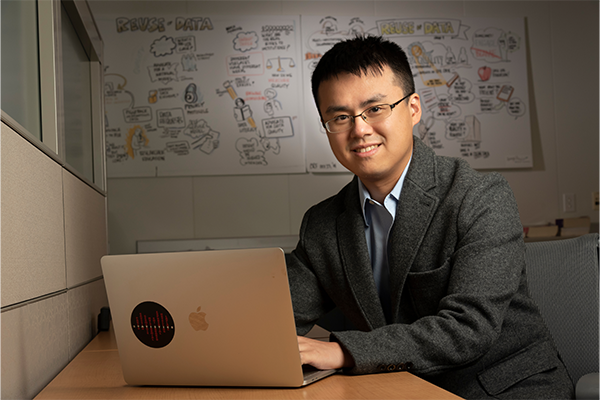 Anru Zhang, PhD sitting at a desk with a laptop