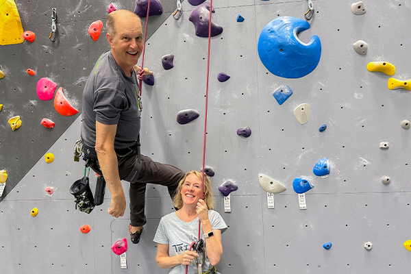 Joel and Caroline Graybeal on a rock wall at their climbing club