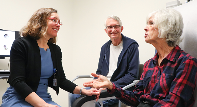 Kim Johnson, MD, visits with a patient and her husband.