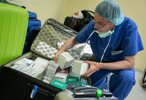 Duke senior heart and transplant surgeon Carmelo A. Milano sorts through the heart valves and pacemakers that were donated by the manufacturers and brought to Honduras as carry-on baggage. Heart valves can cost between $4,000 and $7,000.