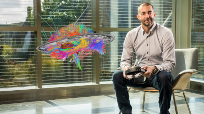 Photo of Cameron McIntyre, PhD, with brain visualization image