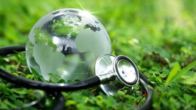 glass globe with stethoscope wrapped around it with greenery background