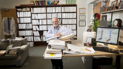 Barton Haynes in his office surrounded by bookcases and publications