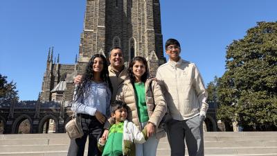 Dr. Vijay and Praveena Ramakrishnan stand with their three children in front of Duke Chapel.