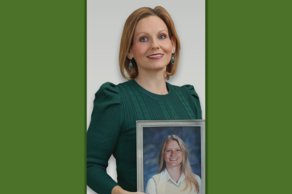 Jamie Cooper Moales holding a portrait of her sister Sara Elizabeth Cooper
