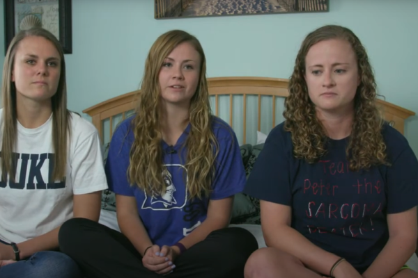 Peter Morrisette's three young adult daughters sitting together on a bed