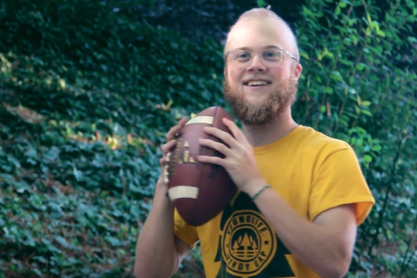 A smiling Graham Rogers holding a football