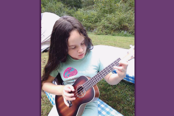 Young girl playing a small guitar
