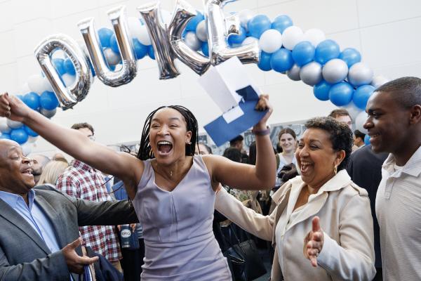 Excited student under Duke balloon banner