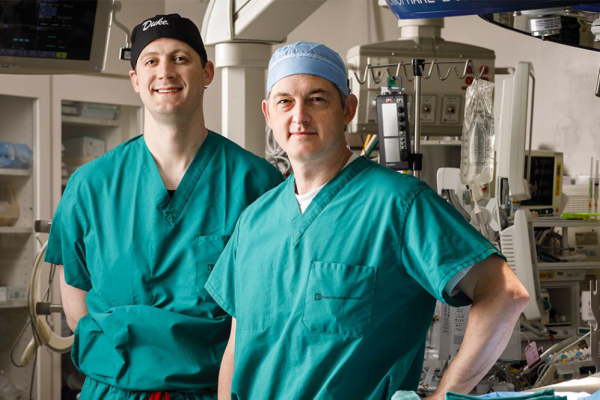 Nick Andersen, MD and Joseph W. Turek, MD, PhD standing in scrubs in an operating room