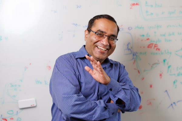 Rohit Singh, PhD, laughing in front of a whiteboard