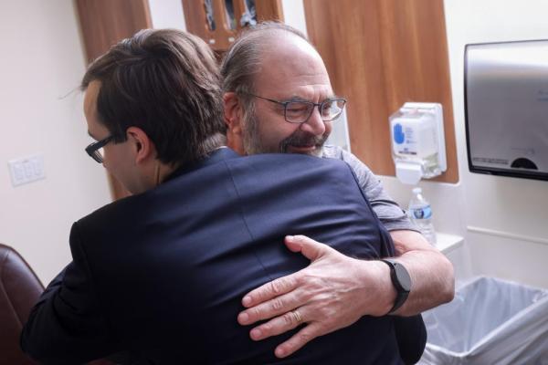 patient gratefully embracing his physician
