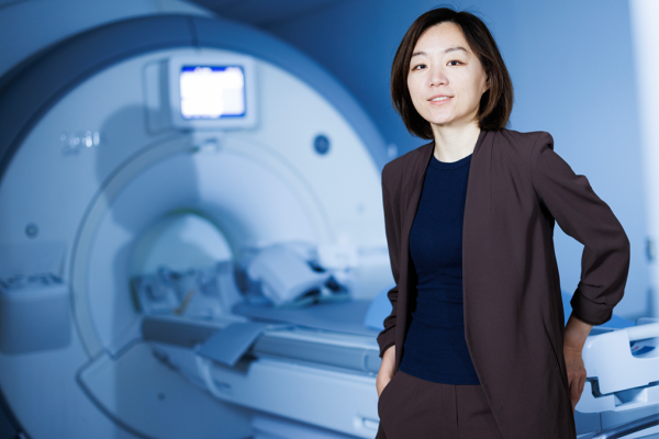 Dan Ma, PhD standing in front of an MRI machine