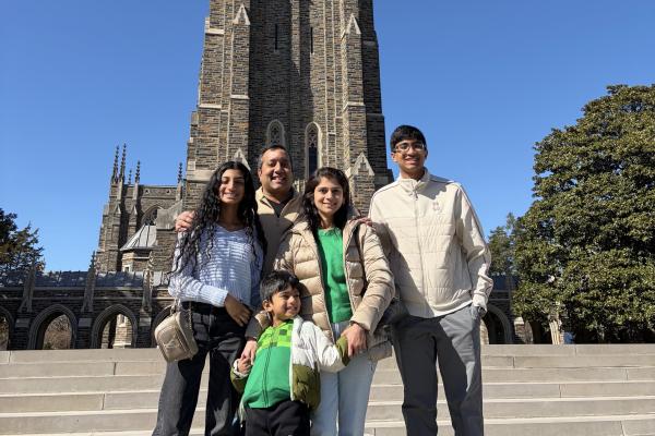 Dr. Vijay and Praveena Ramakrishnan stand with their three children in front of Duke Chapel.