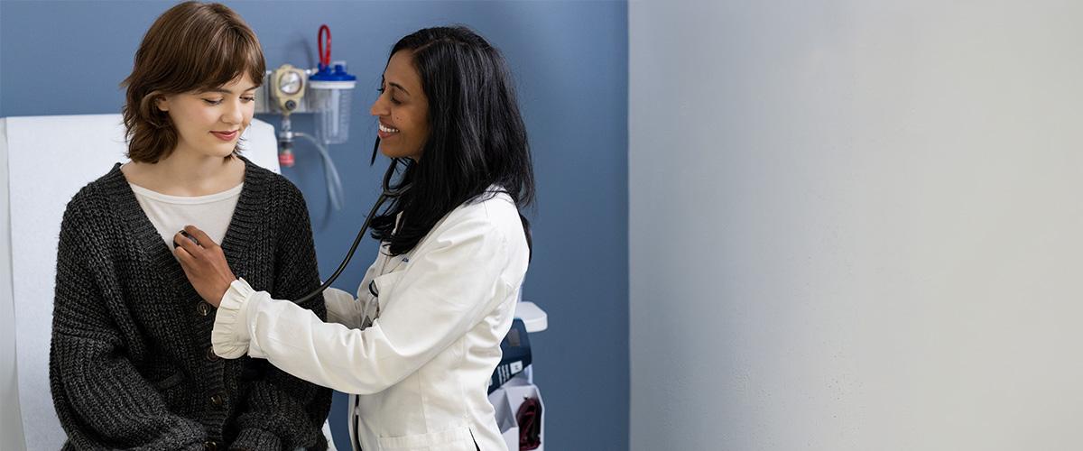 a provider listening to the heartbeat of a patient using a stethoscope