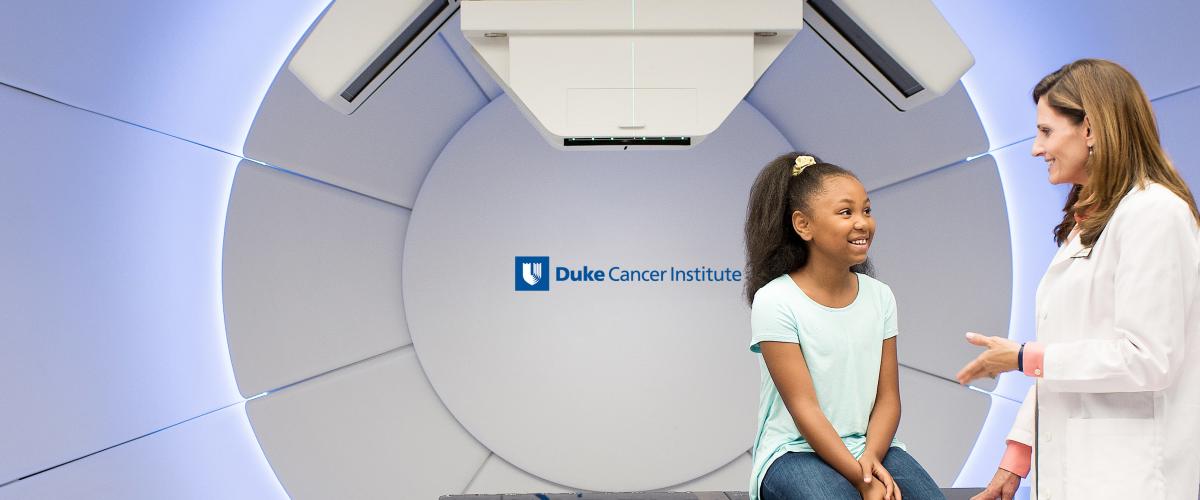 a provider talking to a patient sitting on a scanner