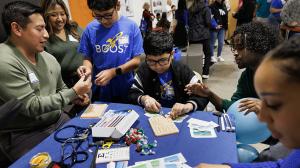 Duke med students  show BOOST students , how to suture during BOOST’s 20th anniversary celebration.