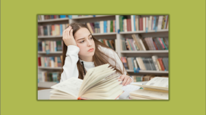young girl at a table in a library with books open, leaning on her hand, looking off into the distance. 