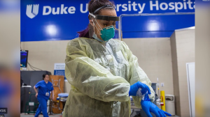 healthcare professional donning PPE during the COVID pandemic at Duke University Hospital