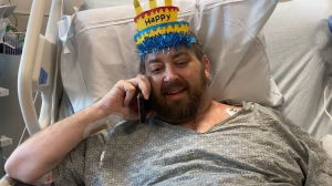 Matthew Moore in hospital bed with party hat