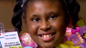 Eight year old Shania Robinson holding up a badge made for her by Duke Healthcare workers.
