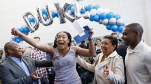Excited student under Duke balloon banner