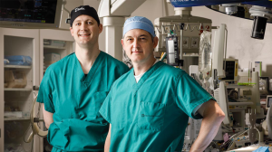 Nick Andersen, MD and Joseph W. Turek, MD, PhD standing in scrubs in an operating room