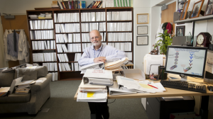 Barton Haynes in his office surrounded by bookcases and publications