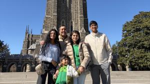 Dr. Vijay and Praveena Ramakrishnan stand with their three children in front of Duke Chapel.
