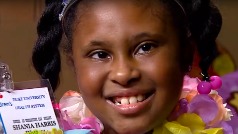 Eight year old Shania Robinson holding up a badge made for her by Duke Healthcare workers.