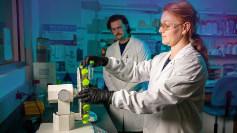 Julia Darcy, Ph.D., Assistant Research Professor in the Department of Electrical and Computer Engineering, loads a centrifuge while  Graham Miller, research Associate, and Sebastian Acosta-Calle, Postdoc Associate, look on
