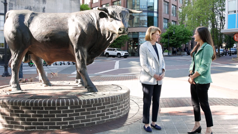 Dean Klotman and Susanna Naggie standing by the Durham Bull sculpture in downtown Durham