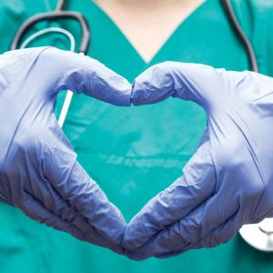 Nurse makes heart with hands