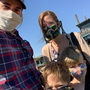 Eric Dziuban with his wife and two children wearing masks outside. 