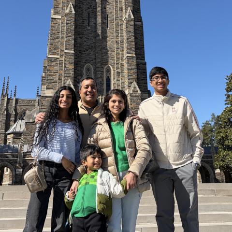 Dr. Vijay and Praveena Ramakrishnan stand with their three children in front of Duke Chapel.