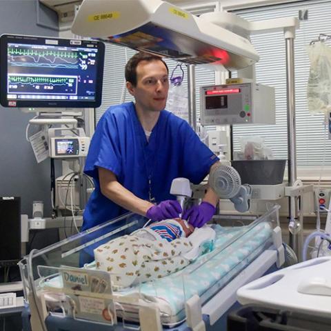 a medical provider performs an eye scan on infant patient
