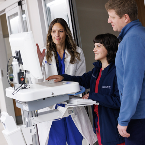 A physician and two providers working at a computer station.