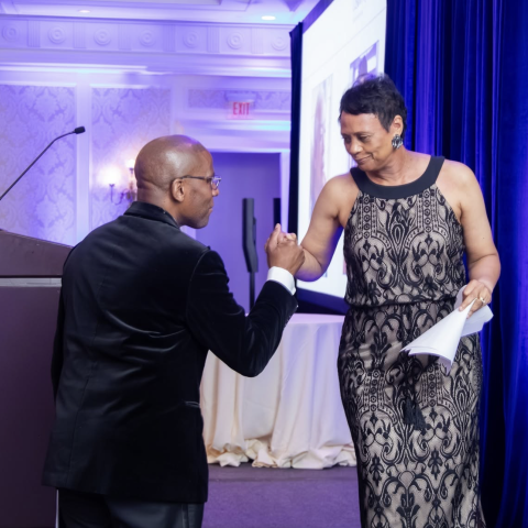 Homecare and Hospice gala, two people passing each other on the stage