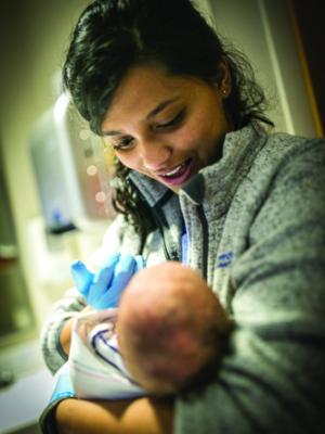 Shree Bose holding an infant