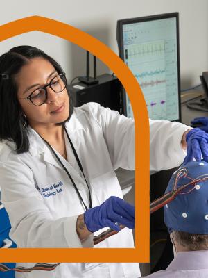 Image of a researcher in psychiatry and behavioral sciences placing electrodes on a person's head