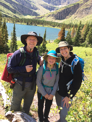 Spancake family on a hike with a lake and mountains in the background