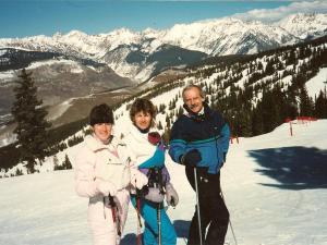 Suzanne, Carole, and Richard Ryan on a ski slope with mountains in the background
