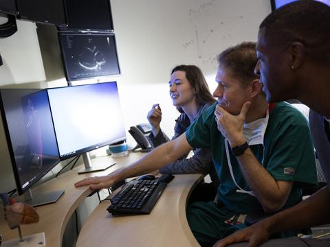Pediatric cardiology team looking at 3D rendering of a heart