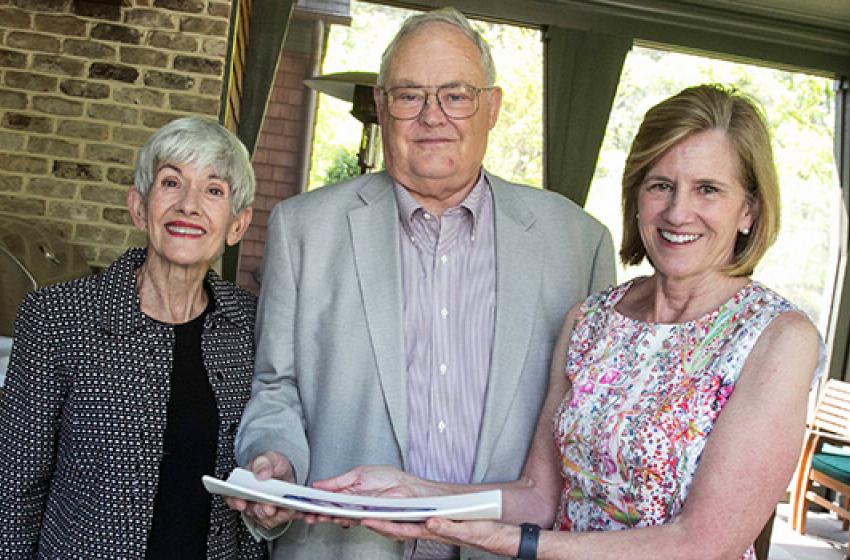 Dean Mary E. Klotman, right, presents Dudley and Michele Rauch with a gift celebrating a milestone in their philanthropic support for Duke University School of Medicine.