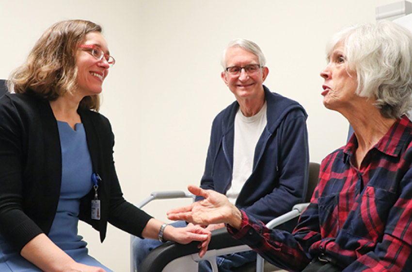 Kim Johnson, MD, visits with a patient and her husband.
